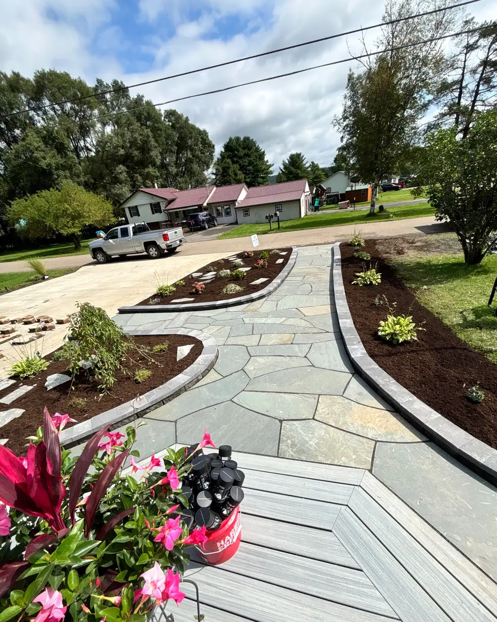 A flagstone walkway curving between freshly mulched planting beds