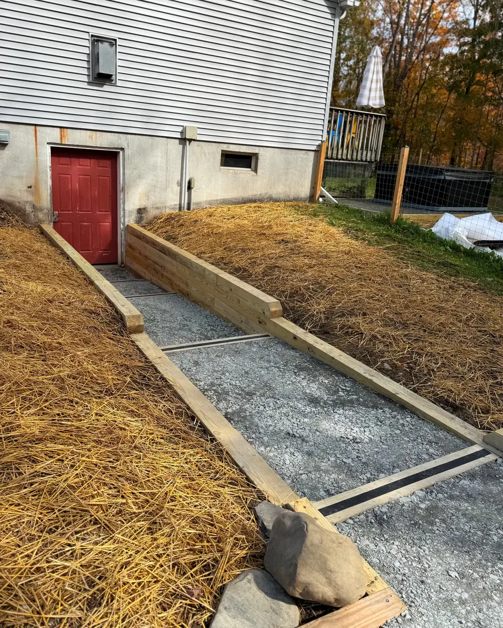 A timber-edged gravel walk running along a regraded, straw-covered bank
