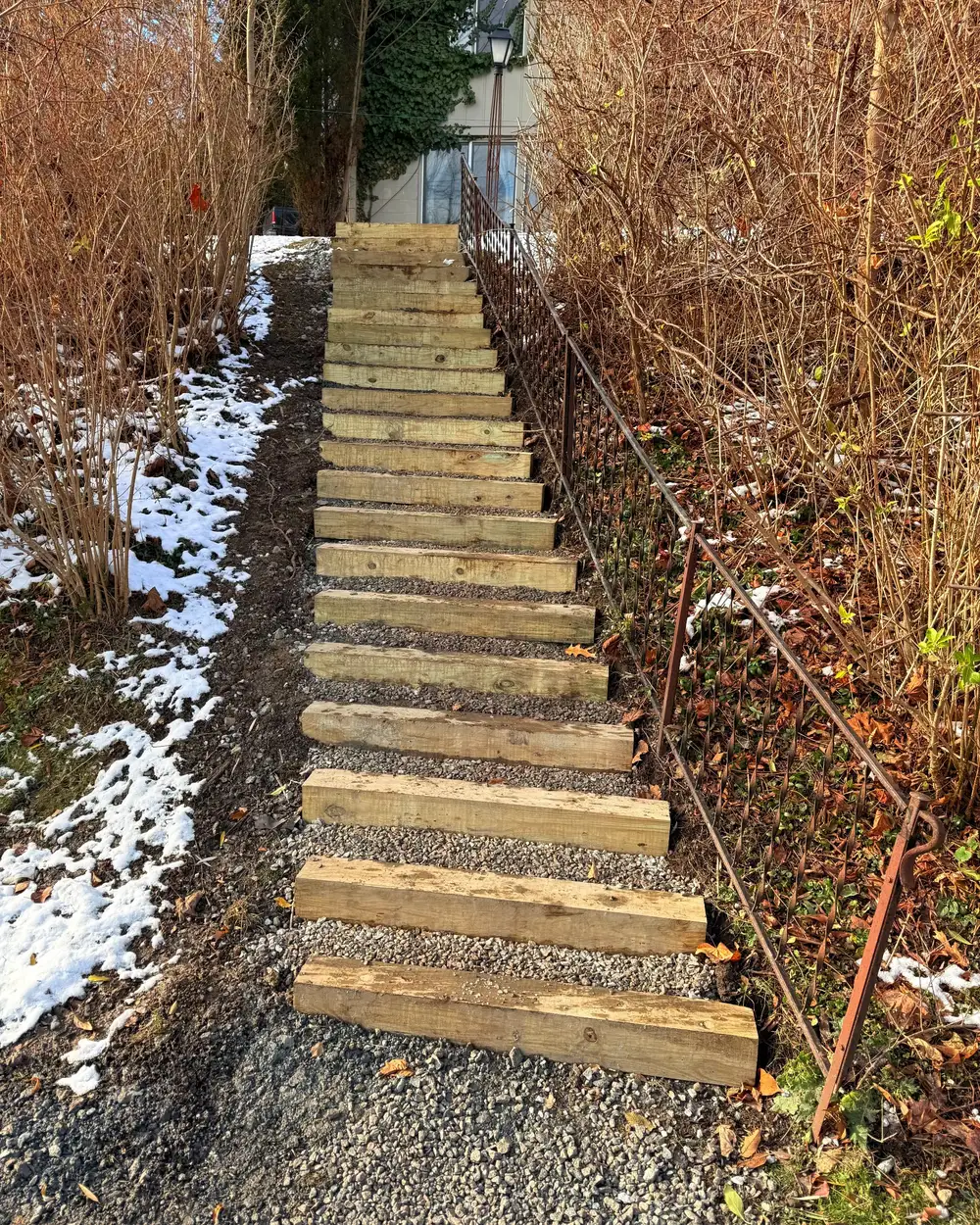Timber steps set into a gravel path climbing a steep bank